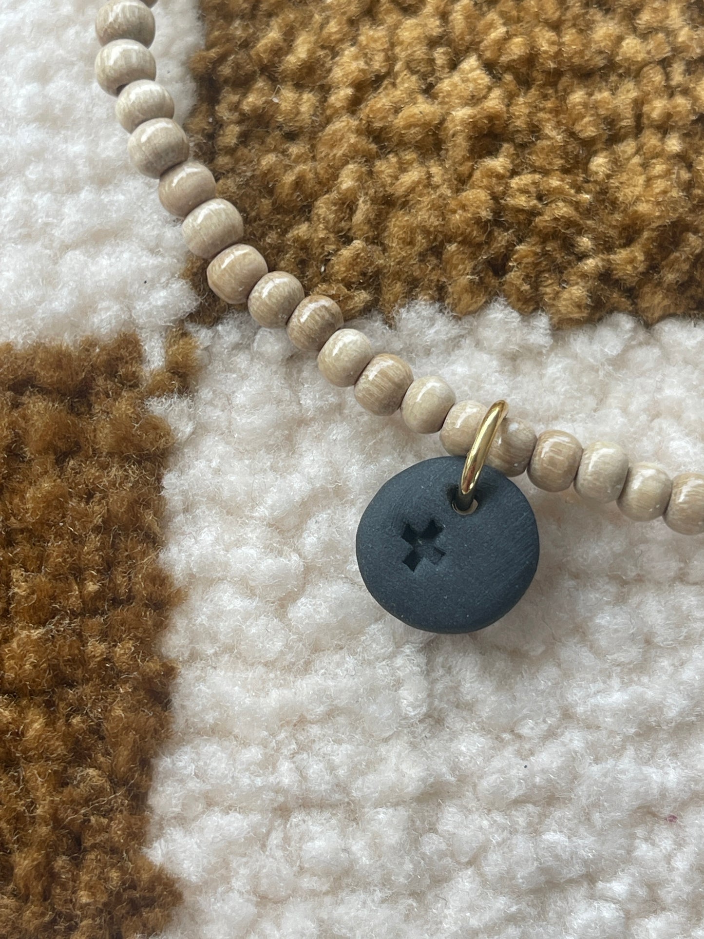 Collier perles de bois et croix gravée sur pampille ronde noire en céramique