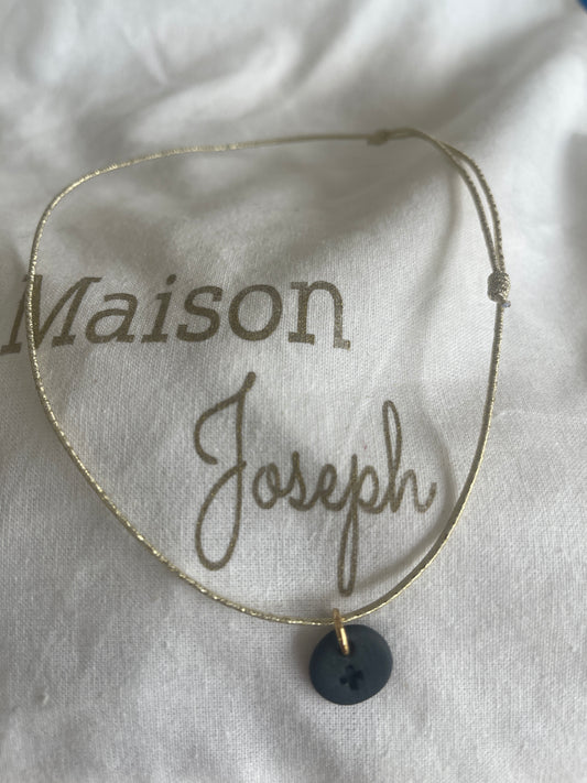 Collier élastique et céramique noire croix gravée sur une pampille ronde