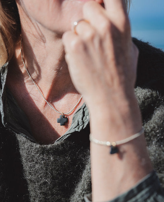 Collier élastique et céramique noire pampille croix